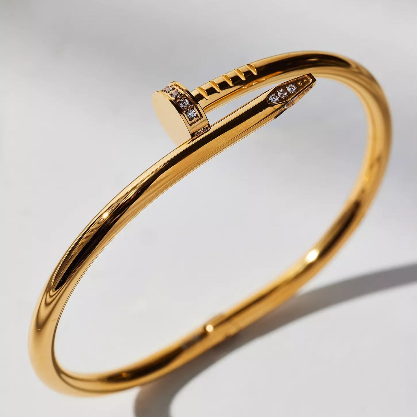 Gold bracelet with diamond accents on a light gray background