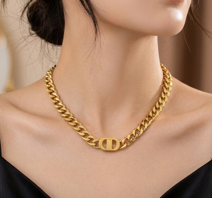 Gold chain necklace worn by a model against a neutral background