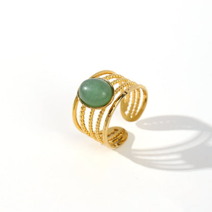 Gold ring with a green gemstone on a white background