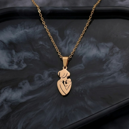 Gold necklace with a heart-shaped pendant on a dark textured surface