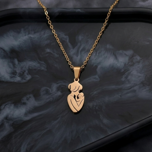 Gold necklace with a heart-shaped pendant on a dark textured surface
