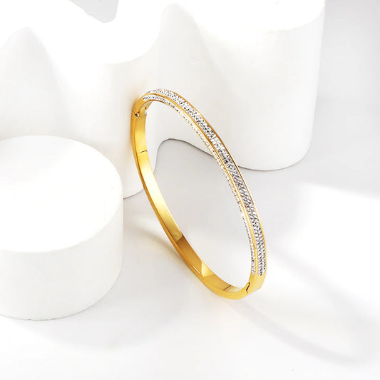 Gold bracelet with embedded stones on a white background